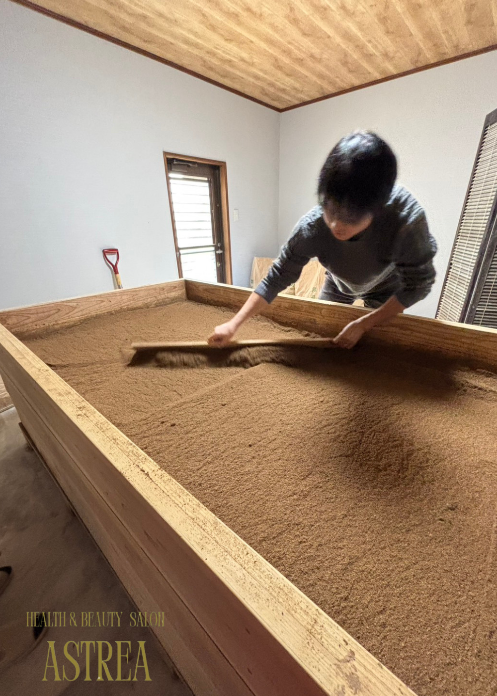 北九州市八幡西区の酵素風呂ASTREA（アストレア）にて、米ぬかを丁寧に整えるスタッフの様子。清潔感のある店内で、ふかふかの米ぬか酵素風呂を提供しています。